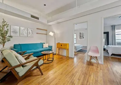 a living room with a blue couch and a table at Three Bedroom Rental in Midtown West , June to Aug 90 days stay required in New York