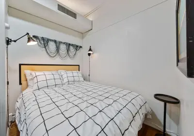 a white bedroom with a bed and a window at Three Bedroom Rental in Midtown West , June to Aug 90 days stay required in New York