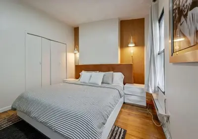 a small bedroom with a bed with a striped blanket at Three Bedroom Rental in Midtown West , June to Aug 90 days stay required in New York