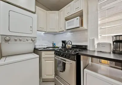 a kitchen with white cabinets and a stove top oven at Three Bedroom Rental in Midtown West , June to Aug 90 days stay required in New York