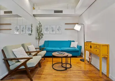 a living room with a blue couch and a table at Three Bedroom Rental in Midtown West , June to Aug 90 days stay required in New York