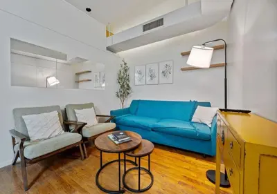 a living room with a blue couch and chairs at Three Bedroom Rental in Midtown West , June to Aug 90 days stay required in New York
