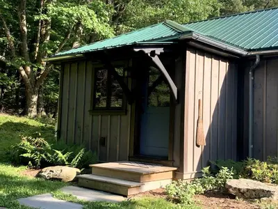 a small shed with a blue door and stairs at Gorgeous Cottage for Two, Overlooking Pond on 20 acres, Glamping in Pennsylvania in Spring Mills