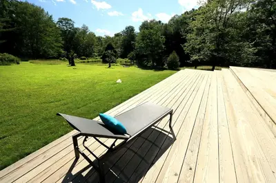 a bench sitting on top of a wooden deck at Gorgeous Cottage for Two, Overlooking Pond on 20 acres, Glamping in Pennsylvania in Spring Mills