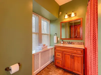 a bathroom with a sink and a mirror and a window at Cozy Home in Historic Harrisburg in Harrisburg