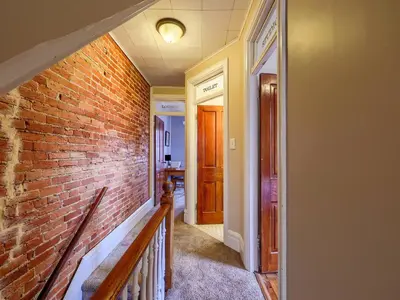 a hallway with a brick wall and a staircase at Cozy Home in Historic Harrisburg in Harrisburg