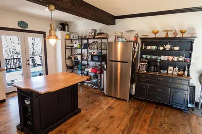 a kitchen with a stainless steel refrigerator and wooden floors at Chic Catskills Farmhouse in Harris