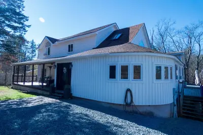 a white house with a gambrel roof at Chic Catskills Farmhouse in Harris