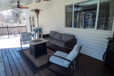 a porch with a couch and a table and chairs at Chic Catskills Farmhouse in Harris