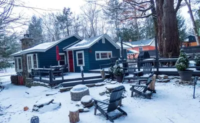 a small blue house with snow on the ground at Enchanted Fox Dell Cottage in Monticello
