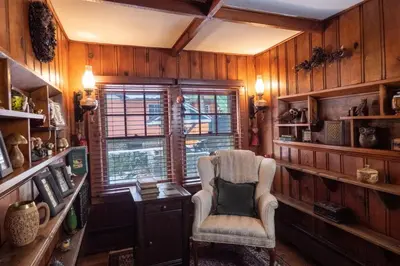 a room with a chair and a desk and a window at Enchanted Fox Dell Cottage in Monticello