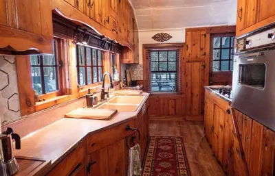 a kitchen with wooden cabinets and a sink at Enchanted Fox Dell Cottage in Monticello