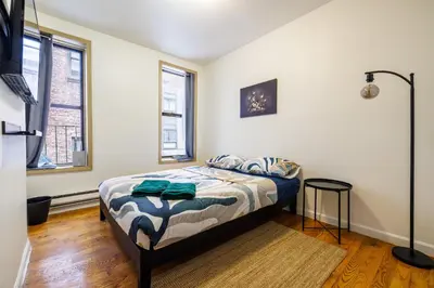 a bedroom with a bed and two windows at Discover the Comfort of Columbia University Area-4 in New York
