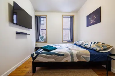 a bedroom with a bed and a flat screen tv at Discover the Comfort of Columbia University Area-4 in New York