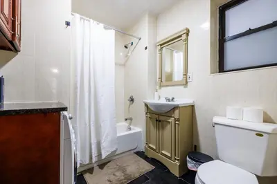 a bathroom with a toilet and a sink and a shower at Discover the Comfort of Columbia University Area-4 in New York
