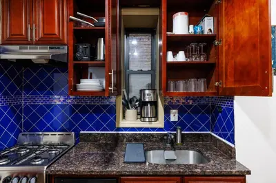 a kitchen with a sink and a stove and blue tiles at Discover the Comfort of Columbia University Area-4 in New York