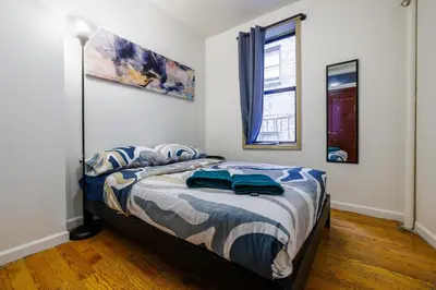 a bedroom with a bed with blue pillows on it at Discover the Comfort of Columbia University Area-4 in New York