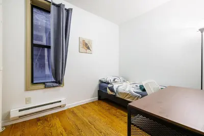 a room with a bed and a window and a table at Discover the Comfort of Columbia University Area-4 in New York