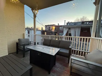 a patio with a couch and a table on a balcony at Heart of Midtown Home on Penn St - Pet Friendly in Harrisburg