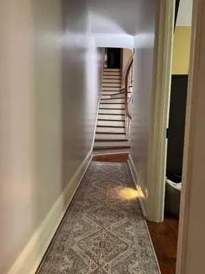a hallway with stairs and a rug on the floor at Heart of Midtown Home on Penn St - Pet Friendly in Harrisburg