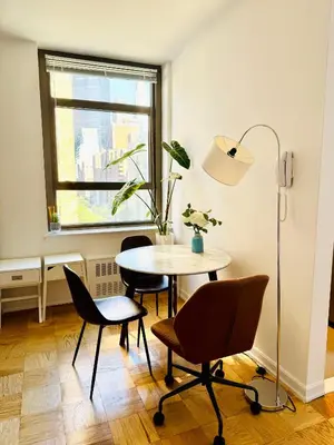 a dining room with a table and chairs and a window at Midtown Park Ave Charming Chrysler View Corner Studio in New York