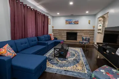 a living room with a blue couch and a fireplace at Cozy Apt Lake Park Station Airport Hospital NJ NYC in Rahway