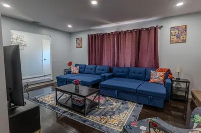 a living room with a blue couch and a tv at Cozy Apt Lake Park Station Airport Hospital NJ NYC in Rahway