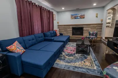 a living room with a blue couch and a fireplace at Cozy Apt Lake Park Station Airport Hospital NJ NYC in Rahway