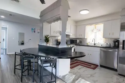 a kitchen with a black table and some chairs at Cozy Apt Lake Park Station Airport Hospital NJ NYC in Rahway