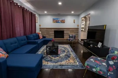 a living room with blue couches and a fireplace at Cozy Apt Lake Park Station Airport Hospital NJ NYC in Rahway