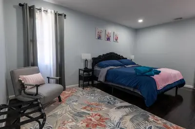 a bedroom with a bed and a chair at Cozy Apt Lake Park Station Airport Hospital NJ NYC in Rahway