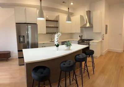 a kitchen with a white counter and stools at Modern 3BR,2BA Apartment in Jersey City, Easy Access to Manhattan in Jersey City