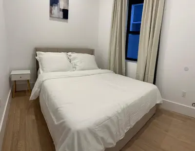 a white bed in a room with a window at Modern 3BR,2BA Apartment in Jersey City, Easy Access to Manhattan in Jersey City