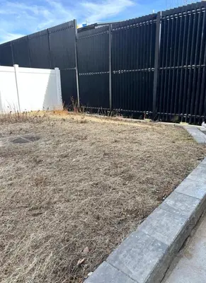 a fence in front of a yard with dirt at Modern 3BR,2BA Apartment in Jersey City, Easy Access to Manhattan in Jersey City