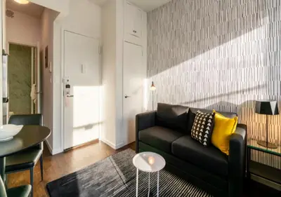 a living room with a black couch and yellow pillows at Studio for 2! Heart of Midtown! in New York