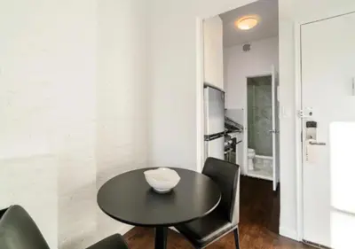 a dining room with a black table and chairs at Studio for 2! Heart of Midtown! in New York