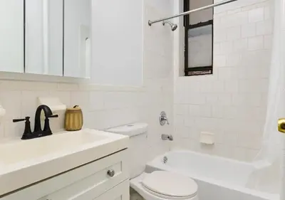 a white bathroom with a toilet and a sink at Studio for 2! Heart of Midtown! in New York
