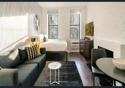 a living room with a couch and a bed at Modern Studio Apartment in NYC! in New York