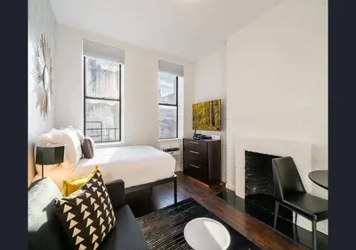 a hotel room with a bed and a fireplace at Modern Studio Apartment in NYC! in New York