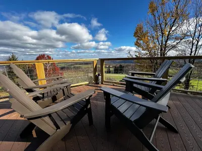 two lounge chairs and a table on a deck at Mountain Retreat Stunning Views Hot Tub Fire Pit in Mehoopany