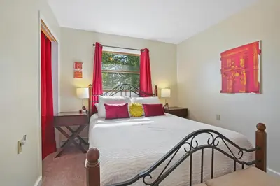 a bedroom with a bed with red curtains and a window at Mountain Retreat Stunning Views Hot Tub Fire Pit in Mehoopany