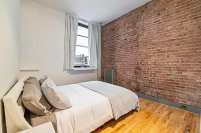 a bedroom with a brick wall and a bed at XL Prime Tribeca Furnished Loft, June To Aug 90 Days Stay Required in New York