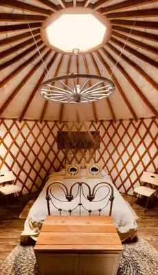 a room with a bed in a yurt with a ceiling at Secluded in the Woods Cedar Hot Tub Pet Friendly in Mehoopany