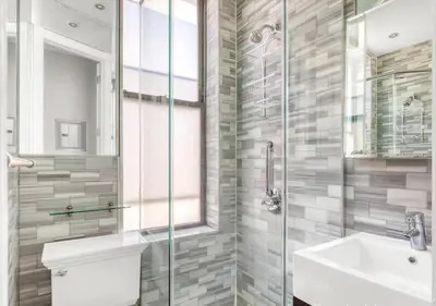 a bathroom with a sink and a glass shower at Midtown West Furnished Apartment 3BR in New York
