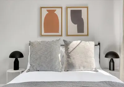 a bedroom with a bed with two pictures on the wall at Midtown West Furnished Apartment 3BR in New York