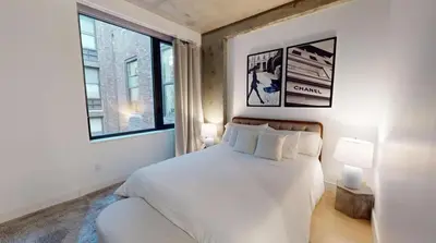 a bedroom with a white bed and two windows at Sleek Two Bedroom in Manhattan in New York
