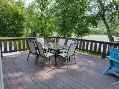 a patio with a table and chairs on a deck at Riverfront Cottage in Owego in Owego