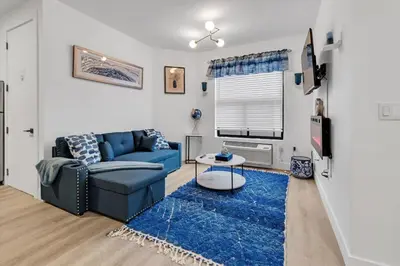 a living room with a blue couch and a blue rug at Blue Bliss Indoor Pool, FREE Parking, Near NYC in Elizabeth