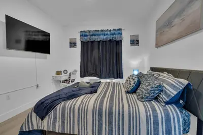 a bedroom with a bed with a striped comforter at Blue Bliss Indoor Pool, FREE Parking, Near NYC in Elizabeth