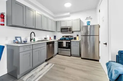 a kitchen with stainless steel appliances and white cabinets at Blue Bliss Indoor Pool, FREE Parking, Near NYC in Elizabeth
